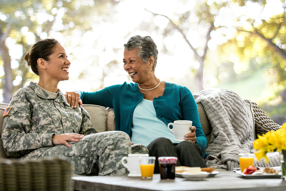 military member and mother sitting and smiling