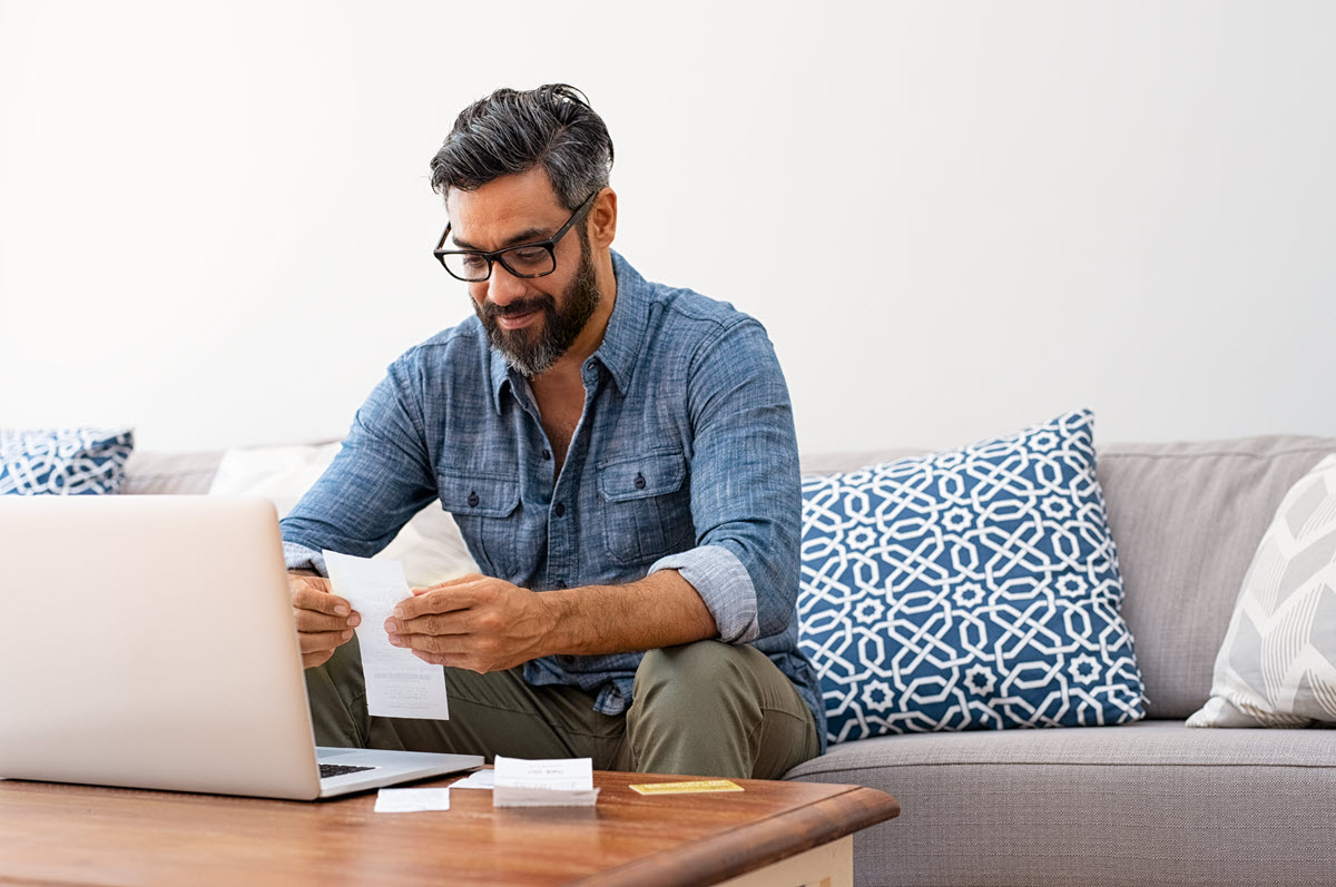 man smiling doing bills