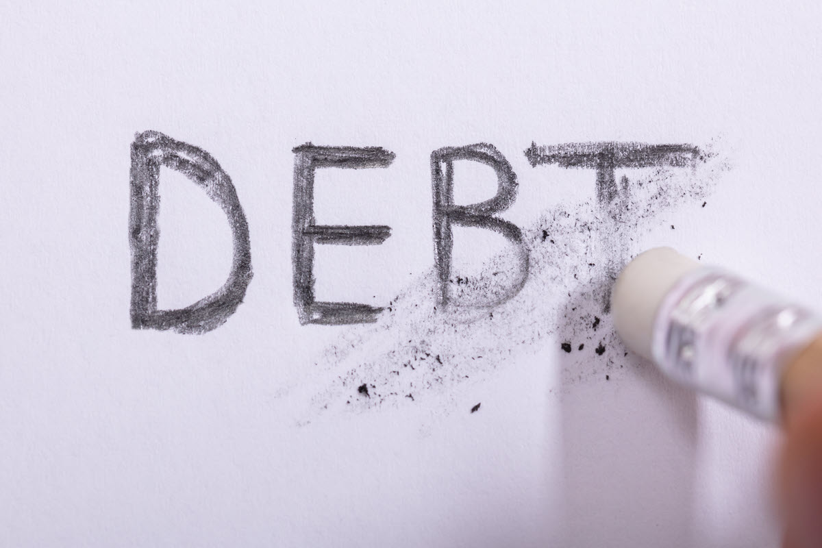 eraser erasing the word debt on paper