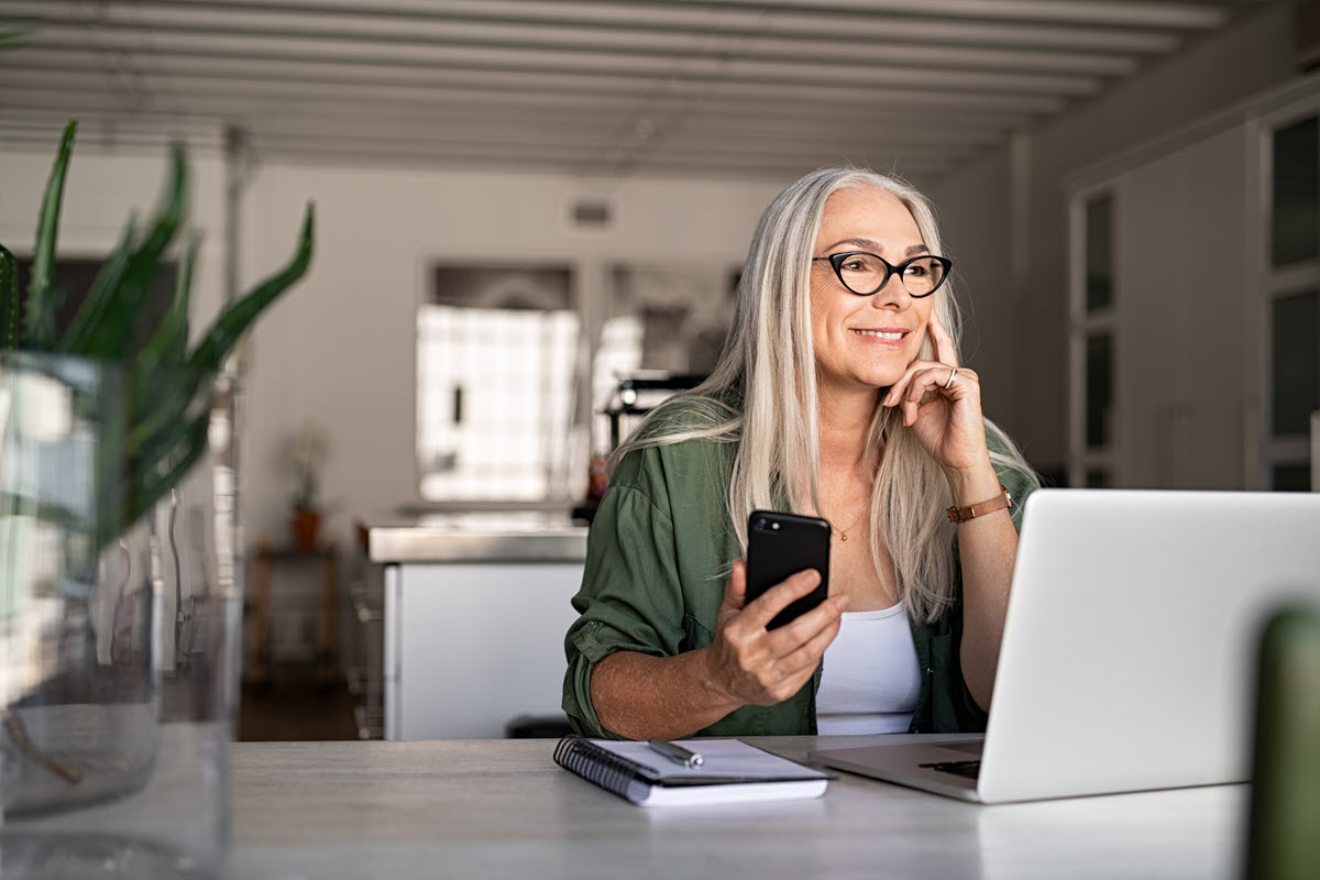 smiling older woman holding a phone