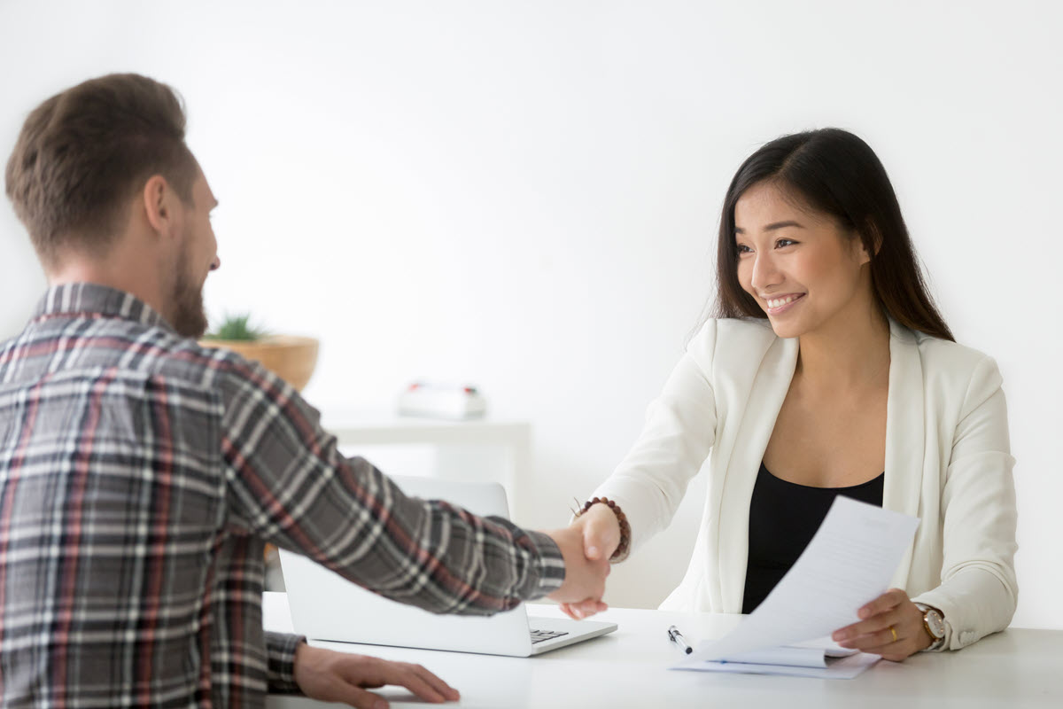 woman and man smiling and shaking hands after an interview