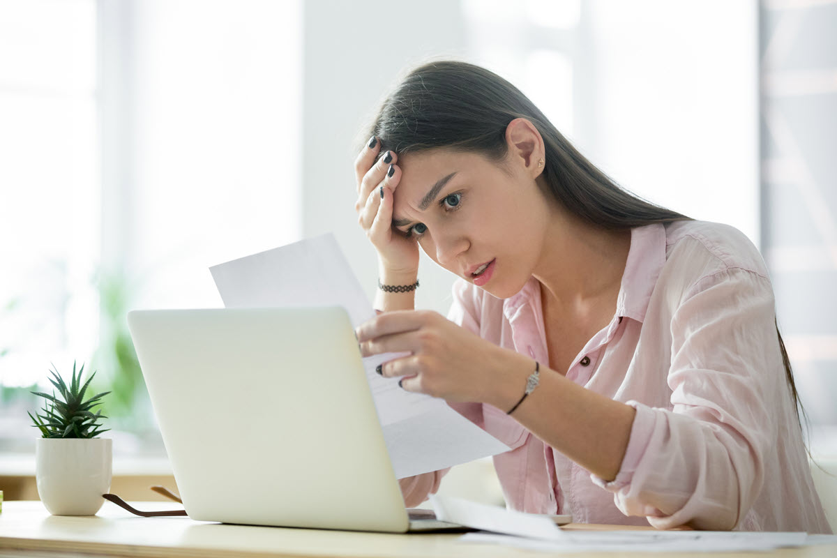 distressed woman looking at a bill