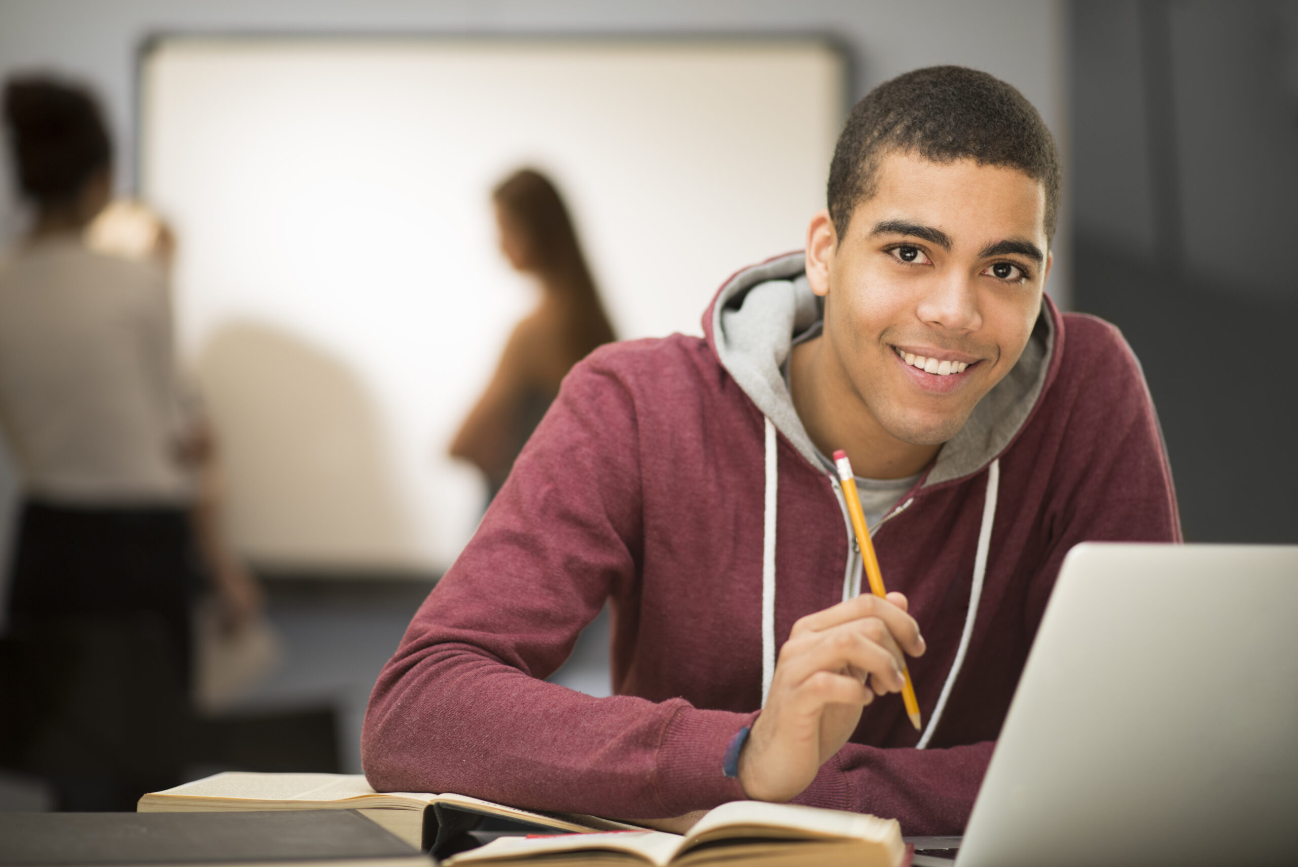 college student smiling in front of a computer