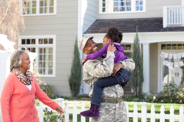 military male holding daughter with grandma watching